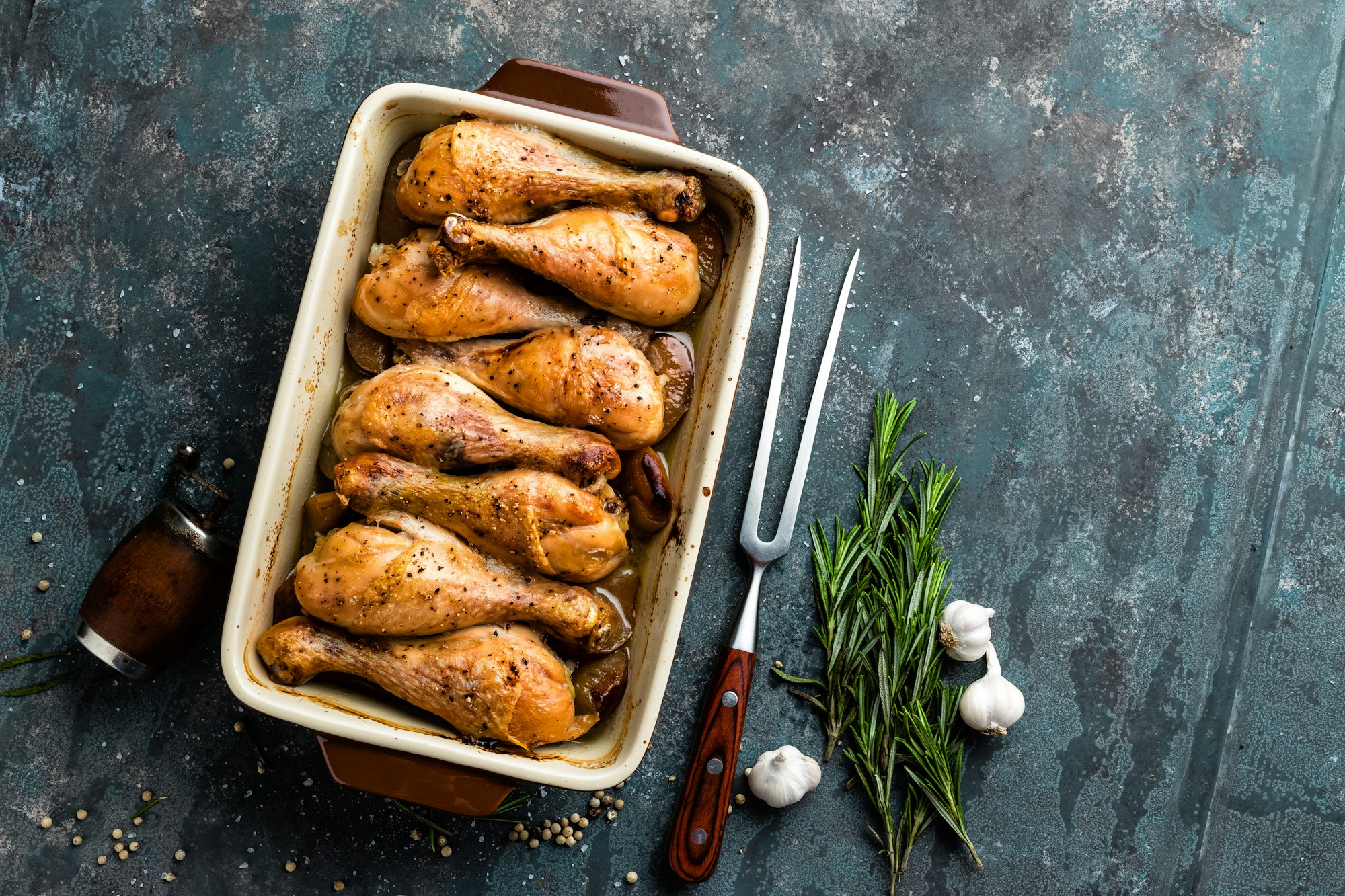 Grilled fried roast chicken legs, drumsticks on dark background, meat with ingredients for cooking