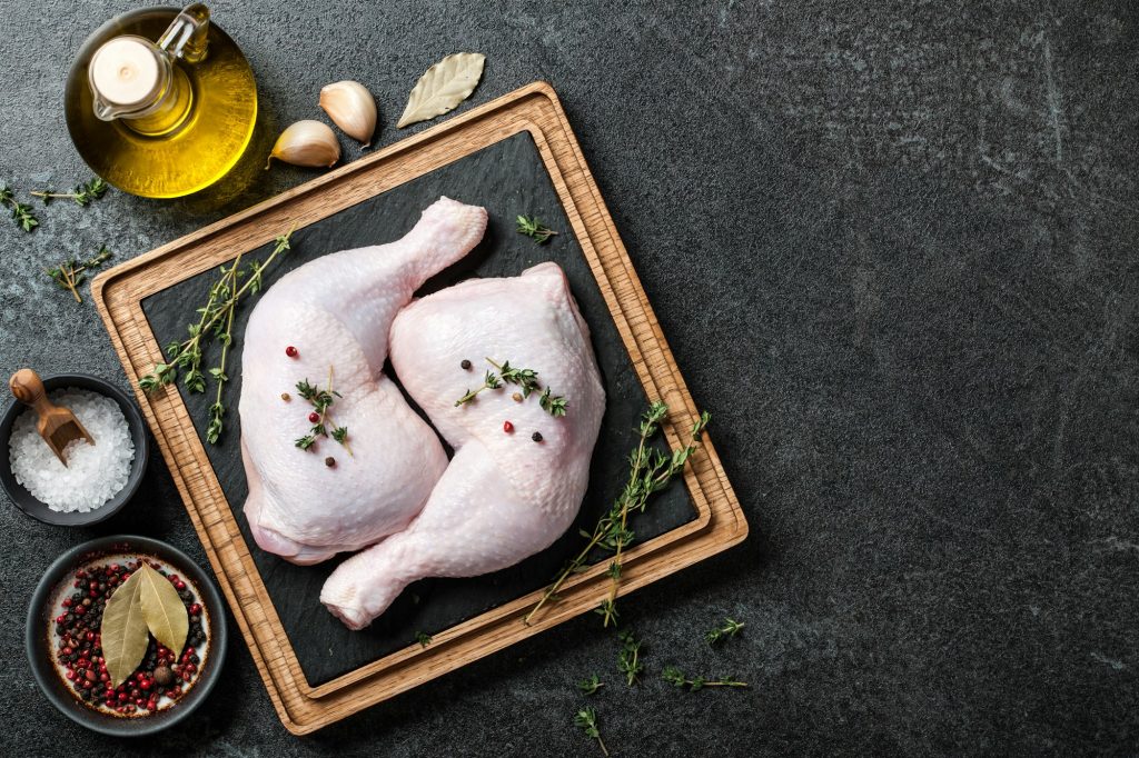 Raw chicken legs on cutting board