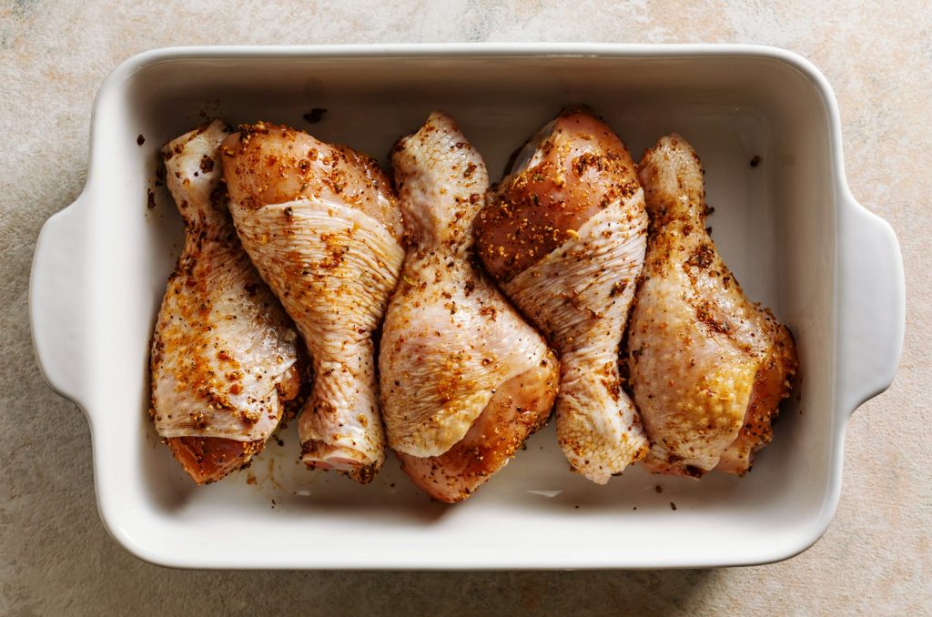 Raw marinated chicken drumstick prepared for baking